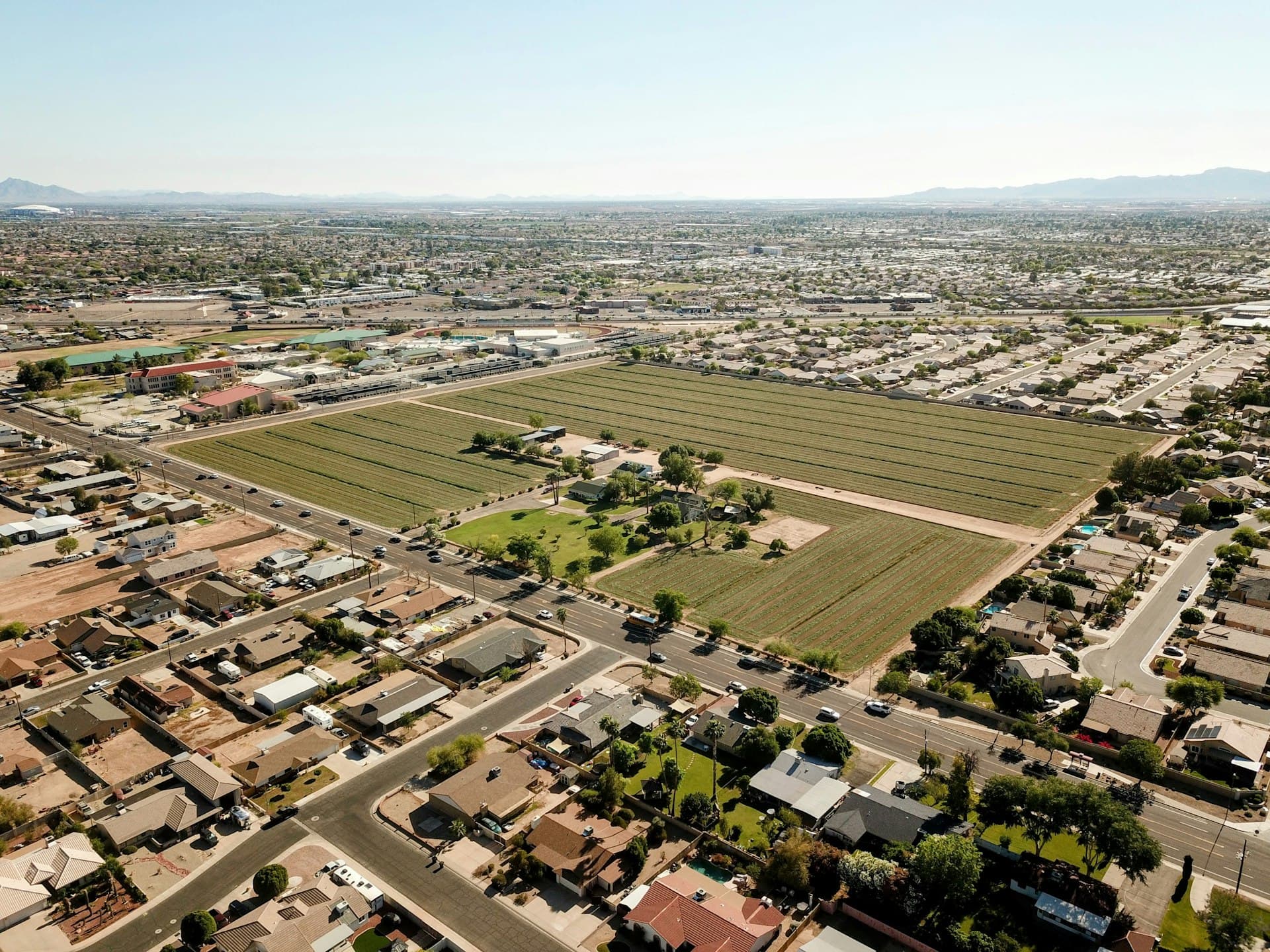 Aerial view of Phoenix metro suburban neighborhoods with farm field