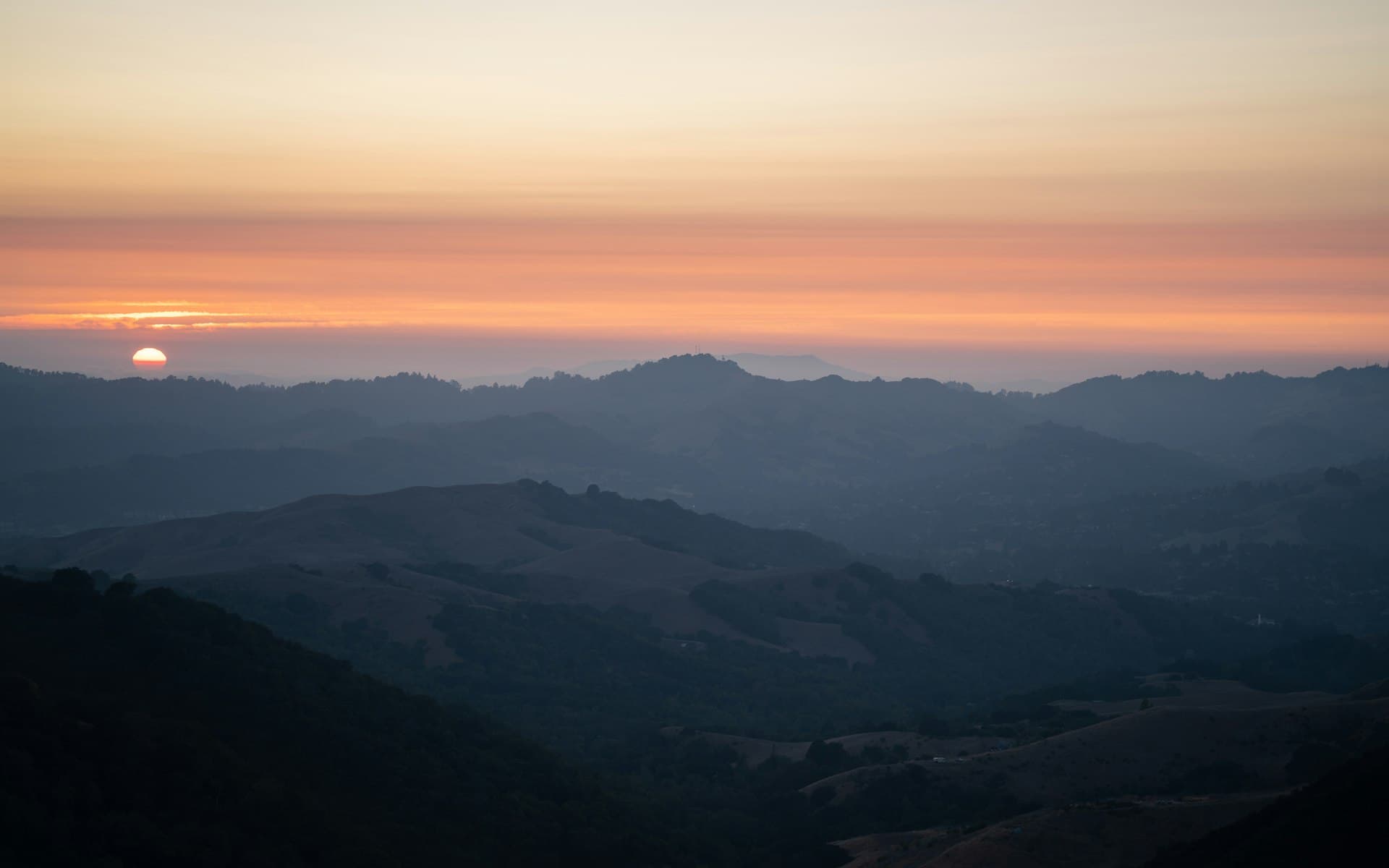 Bay Area hills at sunset with smoky haze from California wildfires affecting air quality