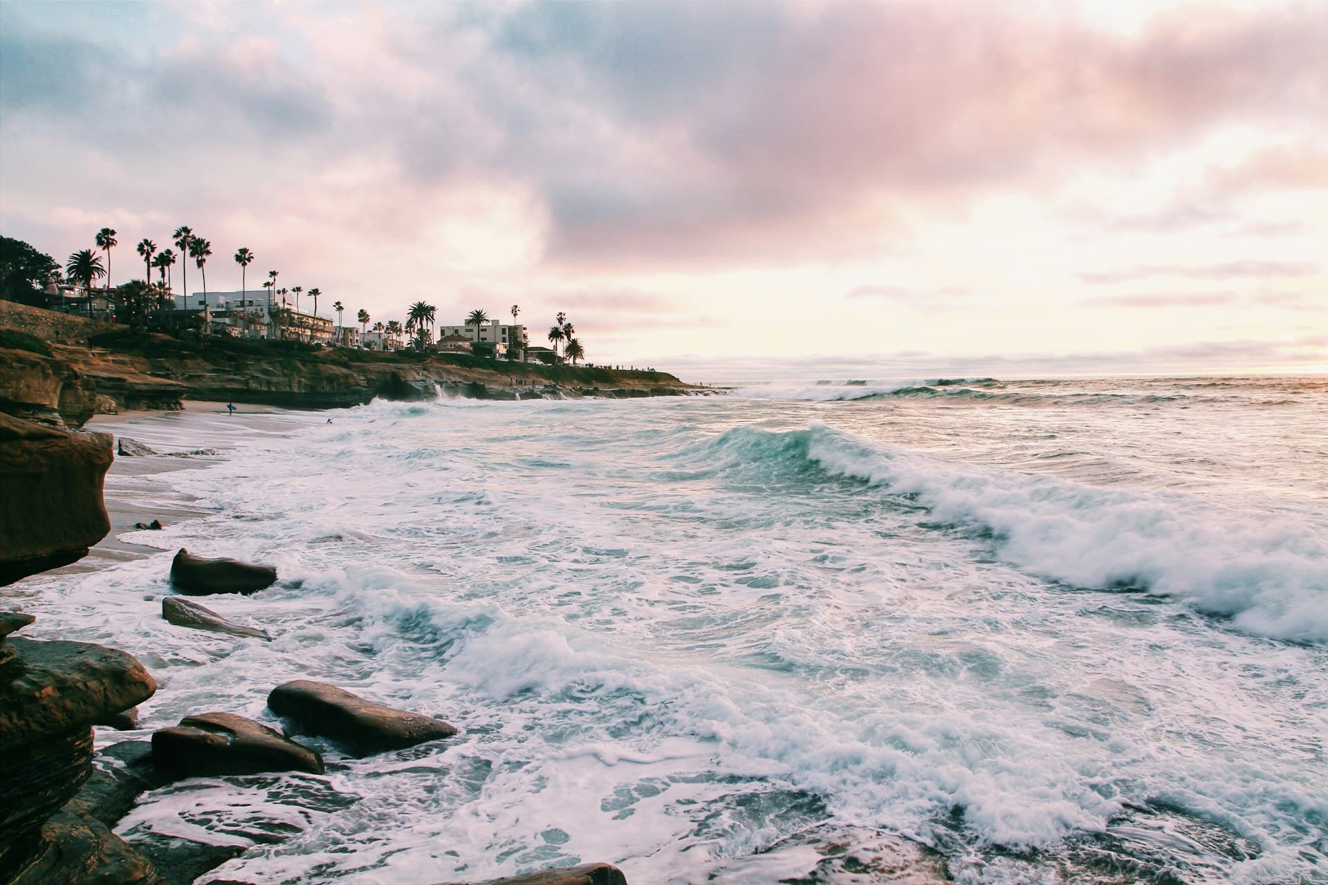 San Diego coastal waves with palm trees and cloudy sky