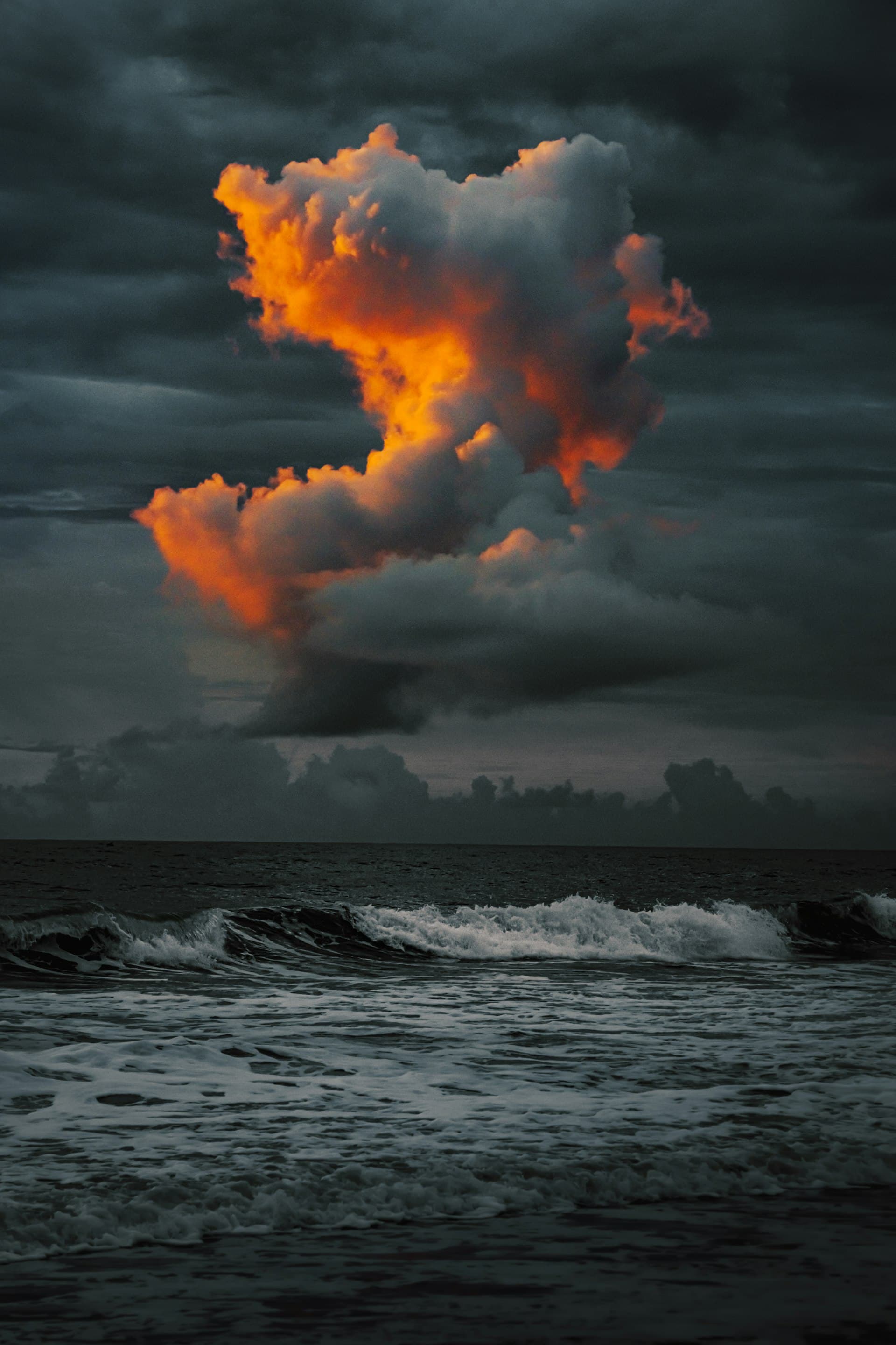 Dramatic Florida storm clouds illuminated at sunrise over Cocoa Beach following Hurricane Ian