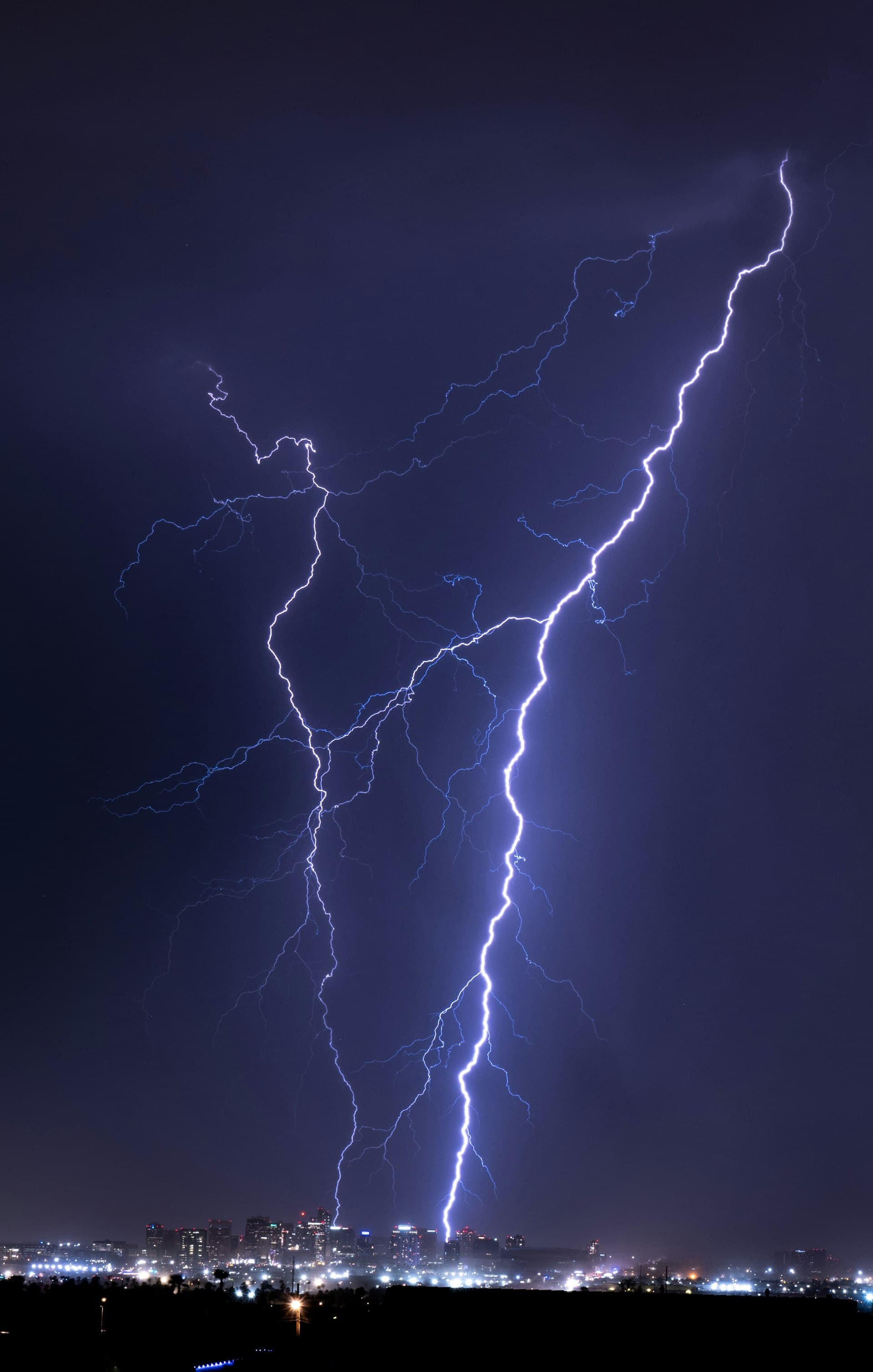 Lightning strikes over Phoenix Arizona city skyline during monsoon thunderstorm